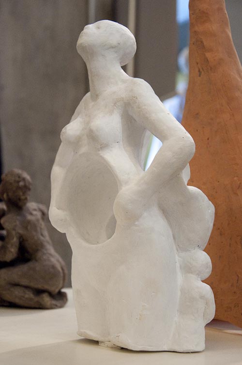 Escultura artística de pessoa com ventre caverna, em gesso branco